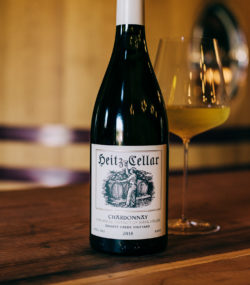 Stylized Heitz Quartz Creek Chardonnay 2018 Bottle on table with glass