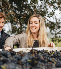 Winemaker Brittany SHerwood and Vineyard Manager Macy Stubstad handle harvested red grapes