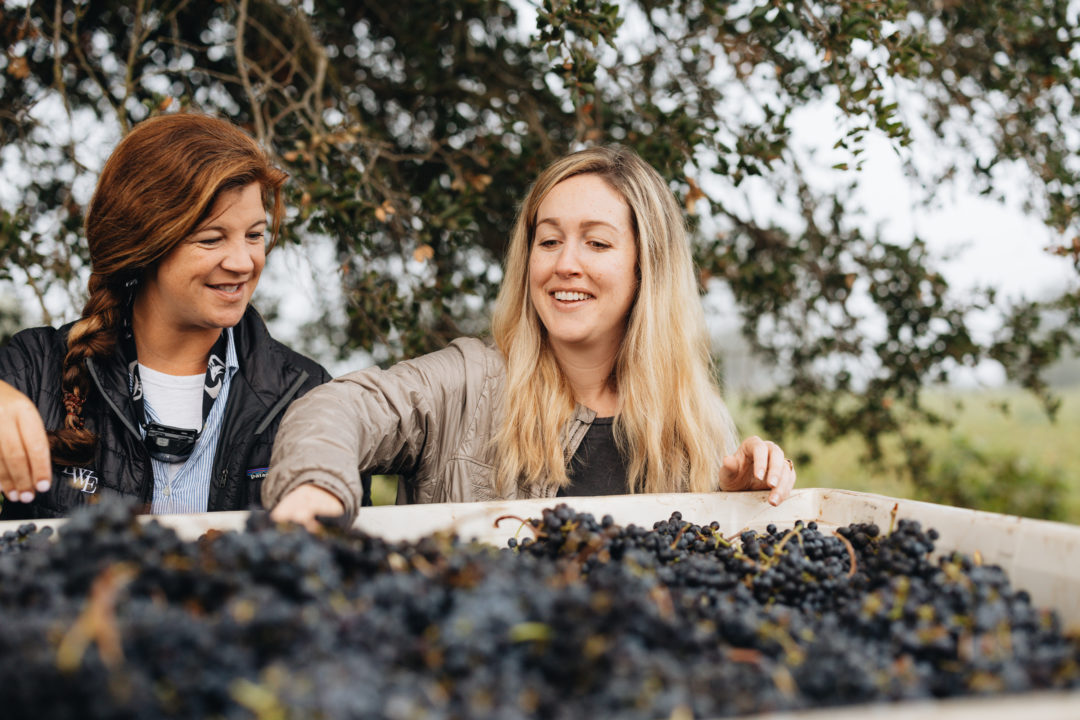 Winemaker Brittany SHerwood and Vineyard Manager Macy Stubstad handle harvested red grapes