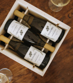Three bottles of Stony Hill 2017 chardonnay in wooden box with glasses on either side