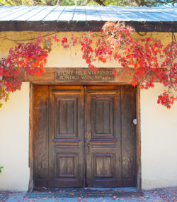 Tasting room doors inscribed with "Stony Hill bonded winery 4461" with red vines hanging overhead