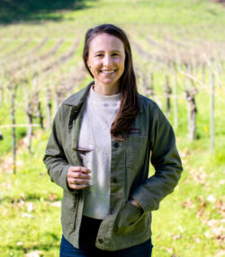 Winemaker Jaimee Motley holding wine glass in the vineyard