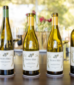Stony hill 2018 white reisling, 2018 and 2017 chardonnay, and 2017 cabernet sauvignon bottles lined up on table in tasting room