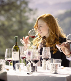 Meghan Zobeck and Carlton McCoy taste Burgess wines at outdoor table with bottle and glasses