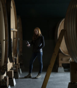 Meghan Zobeck with wine glass in cellar