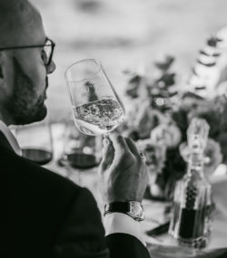 Carlton McCoy swirls a glass of Ink Grade Napa Valley Sauvignon Blanc black and white
